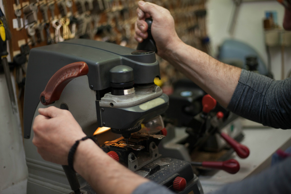 locksmith is operating a key cutting machine