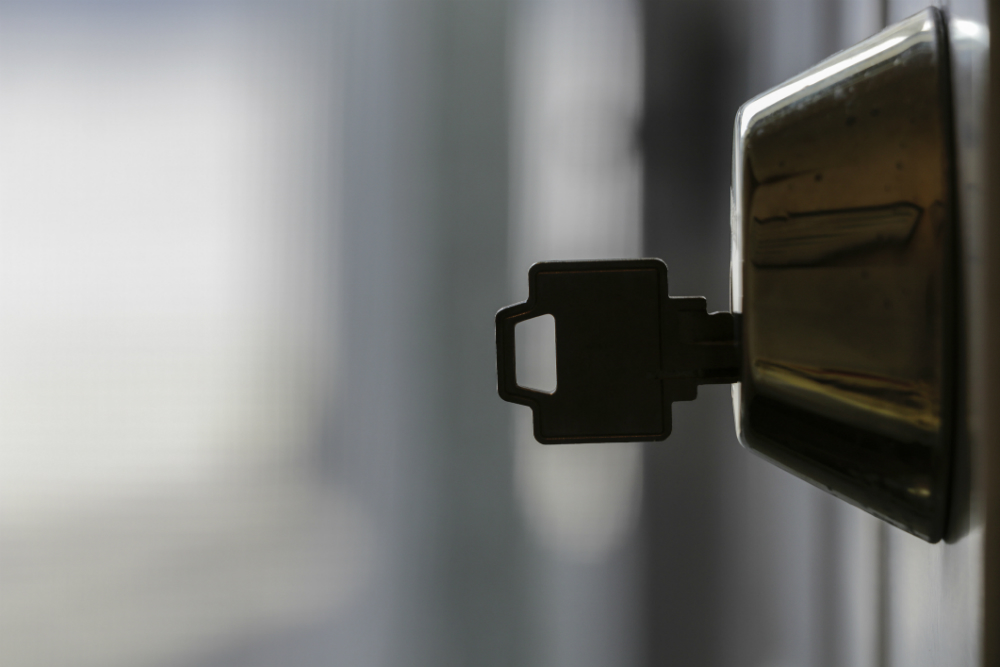 image shows a door knob with key inserted into it